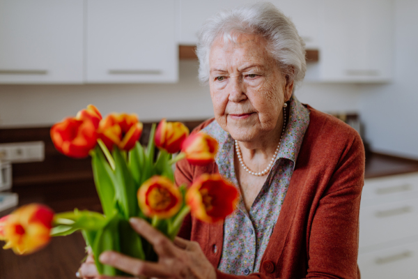 Portrait of senior woman with bouquet of flowers.