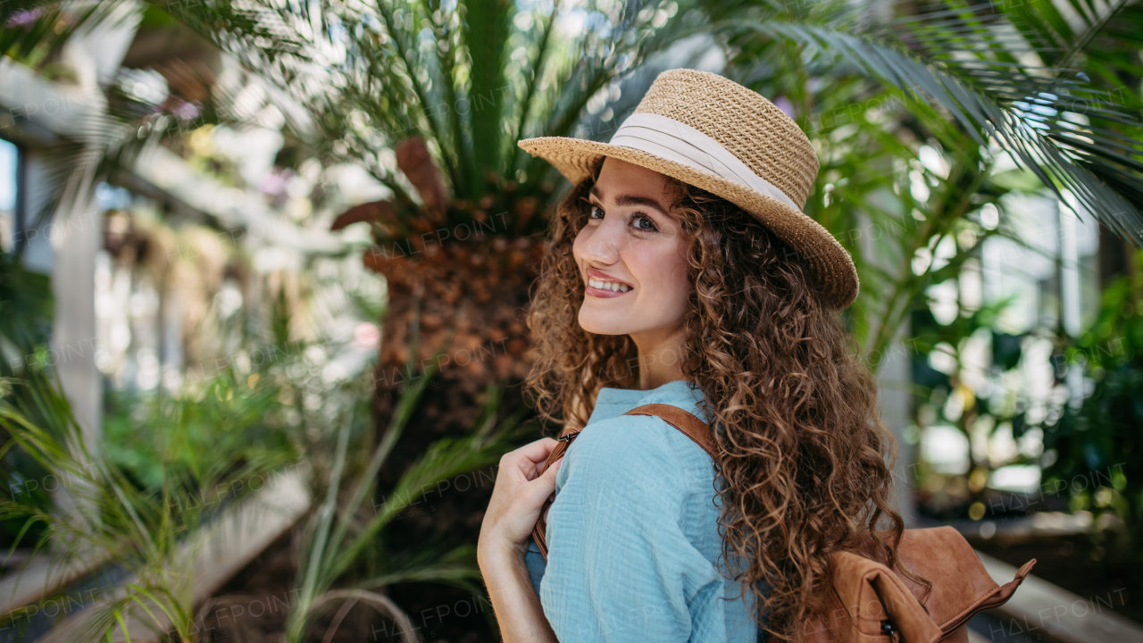 Portrait of young beautiful woman in botanical garden.