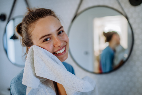 Young woman taking care of her face skin, morning beauty routine concept.