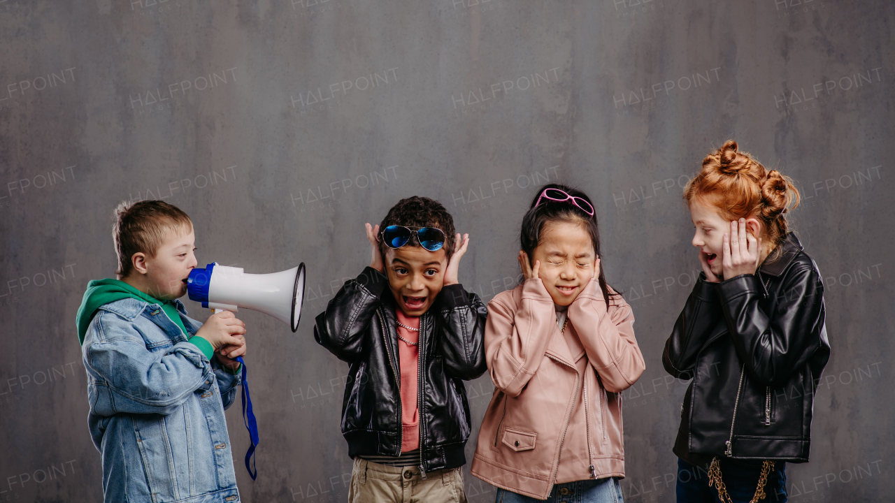 Studio shoot of a child with megaphone shouting at other children.