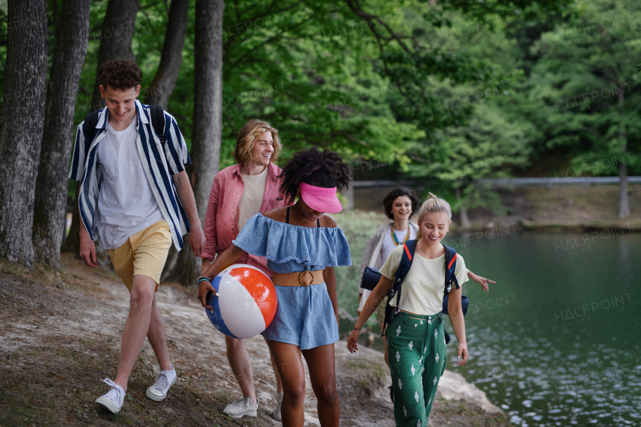 A group of young friends on camping trip near lake in summer.