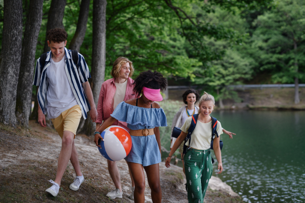 A group of young friends on camping trip near lake in summer.