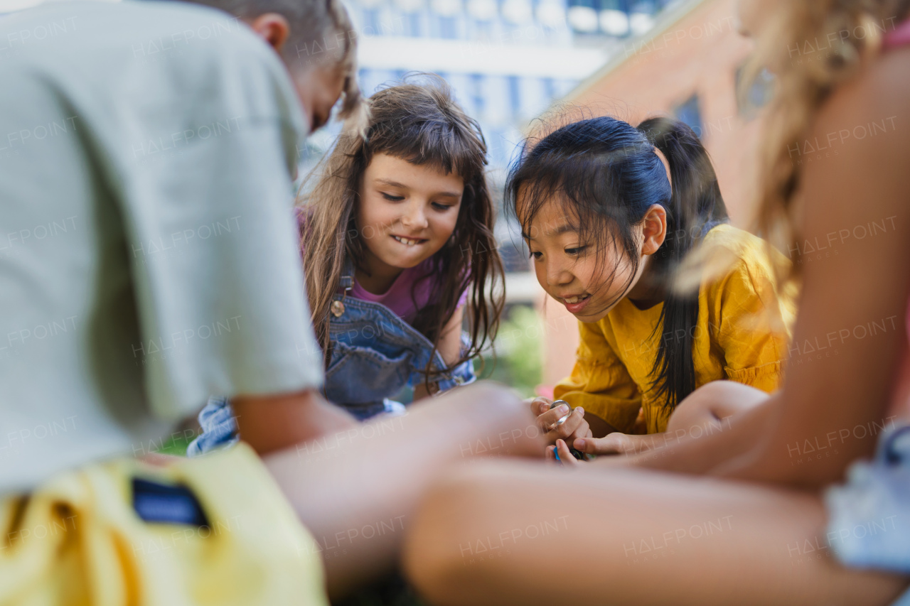 Happy kids playing and talking together in s city park, during summer day.