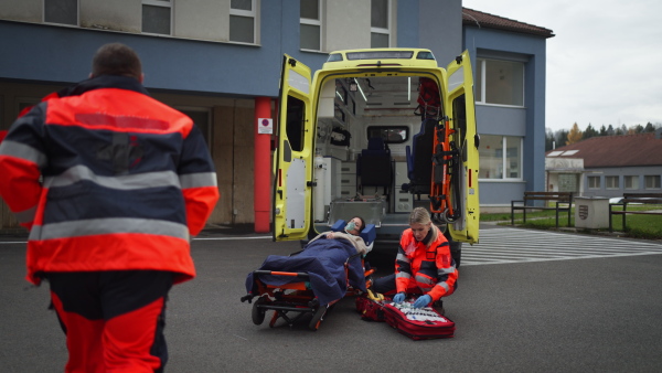 Rescuers taking care of a patient, preparing her for transport.