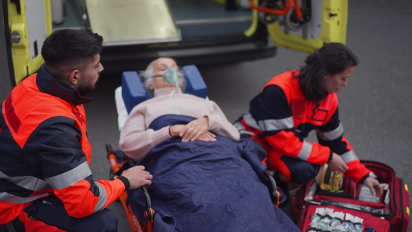 Rescuers taking care of a patient, preparing her for transport.