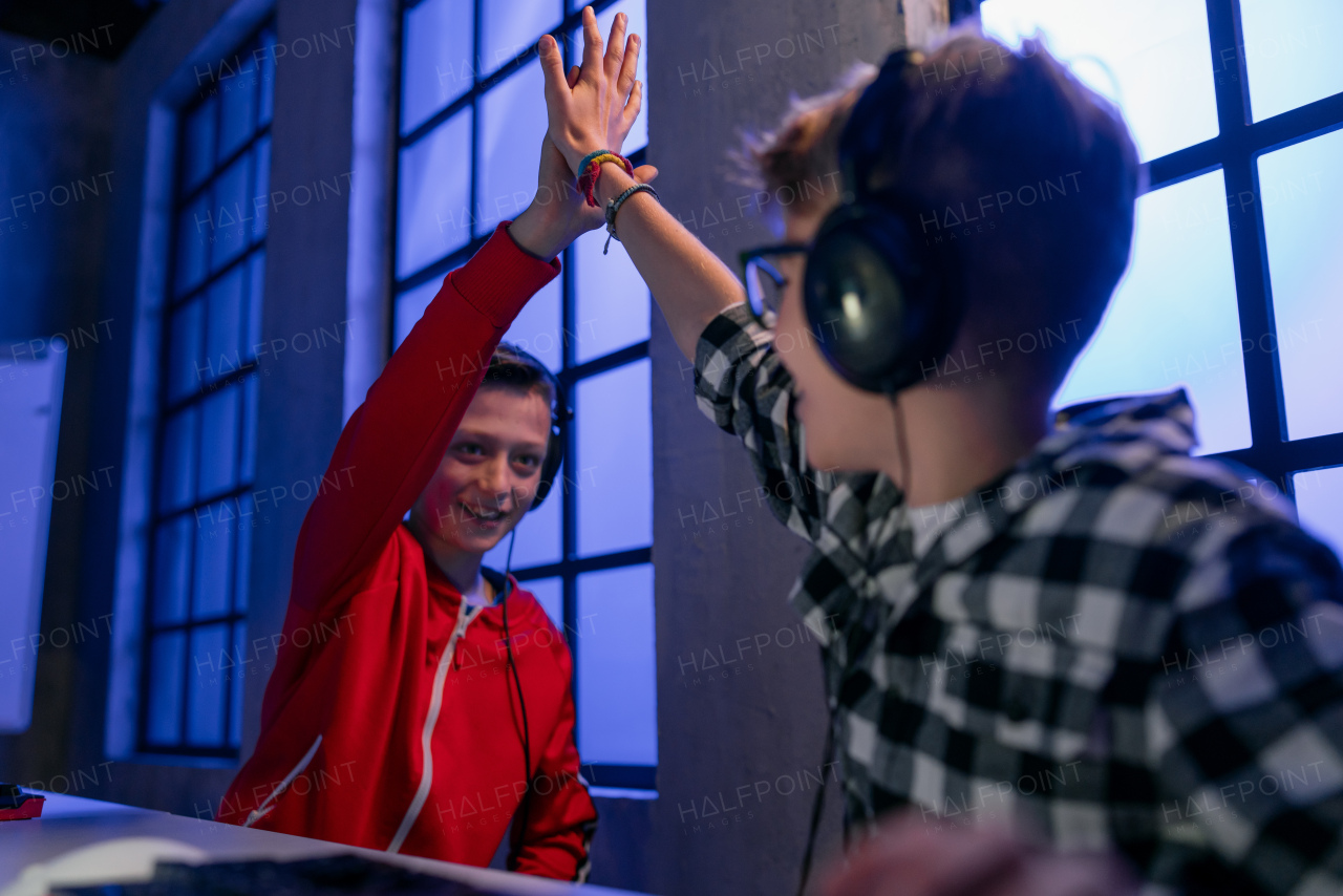 cheerfull gamer boys with headphones playing a computer video game.