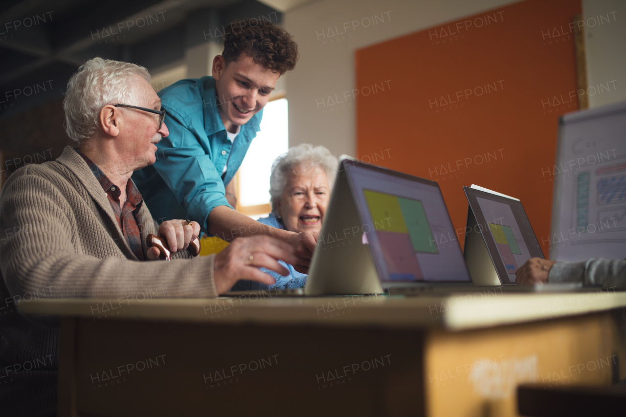 A senior group in retirement home with young instructor learning together in computer class