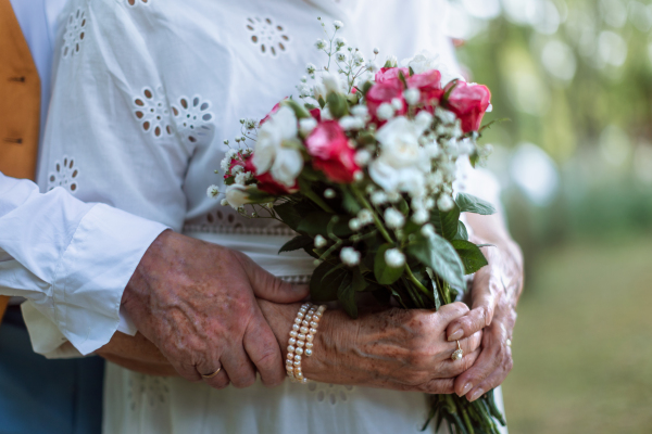Close-up of seniors hands with golden wedding rings during their marriage.