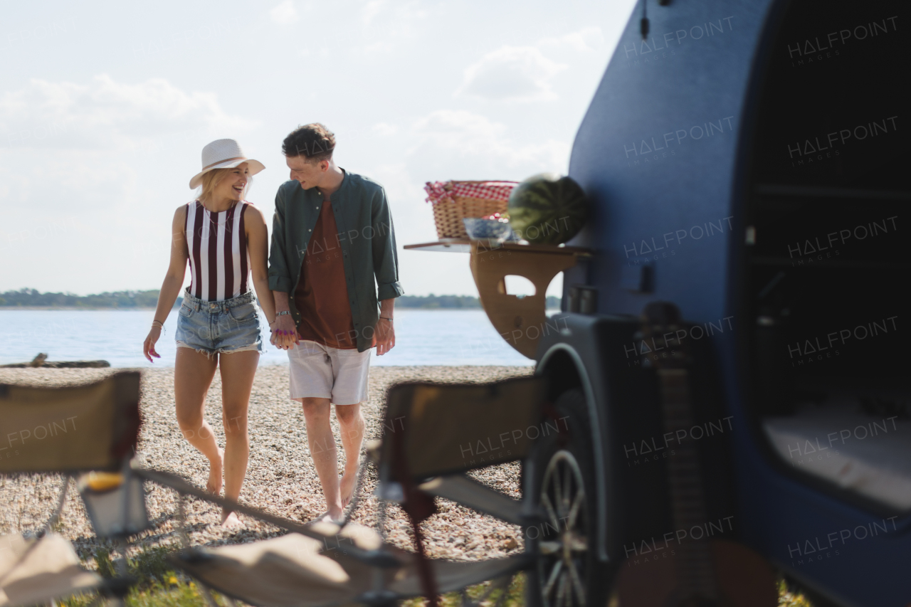 Young couple in front of van during summer holiday.