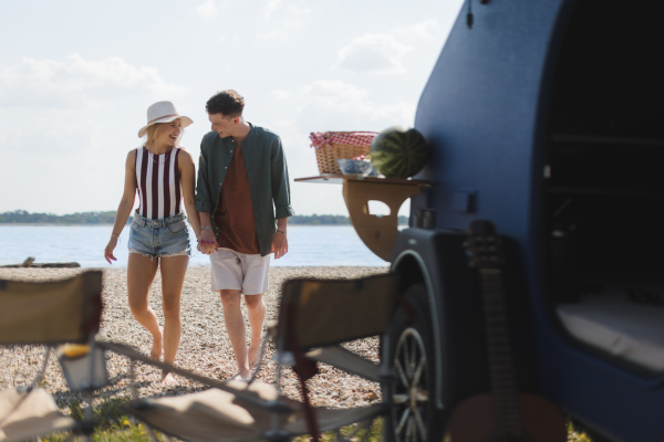 Young couple in front of van during summer holiday.