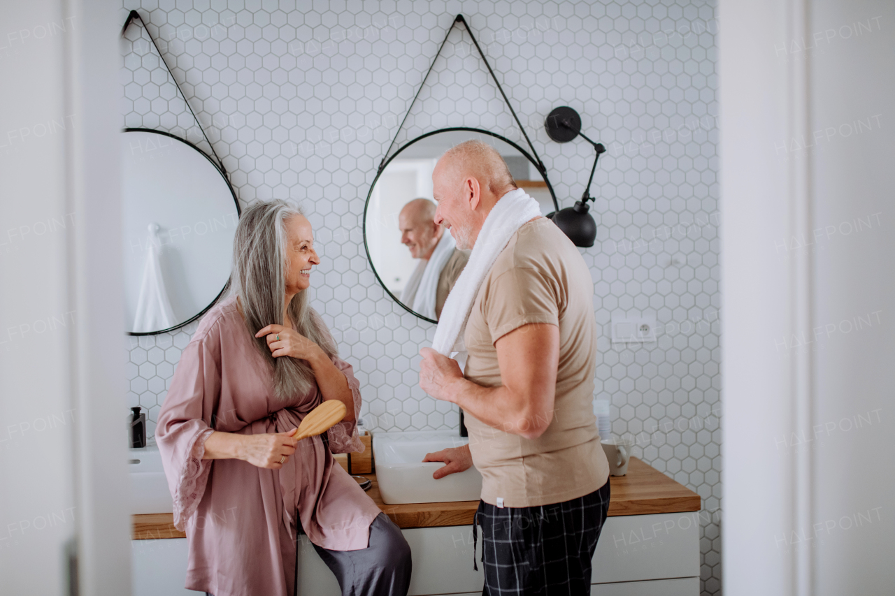 A senior couple in love in bathroom, talking, morning routine concept.