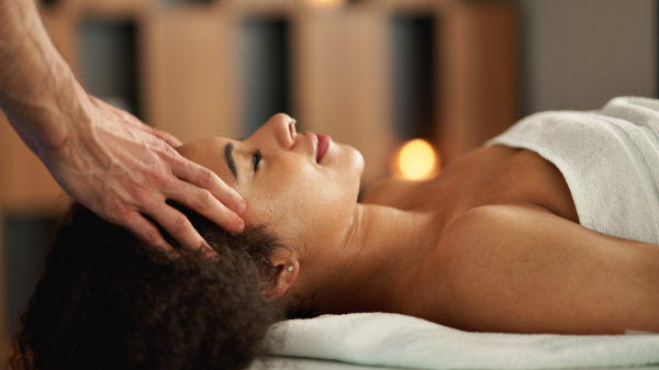 Young woman having relaxing head massage at the spa.