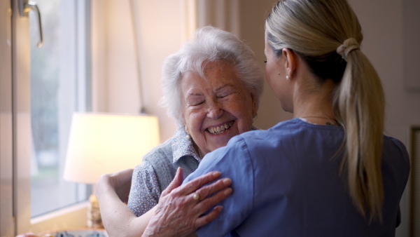 Psychologist, caregiver provides mental health support and grief counseling to female elderly patient.