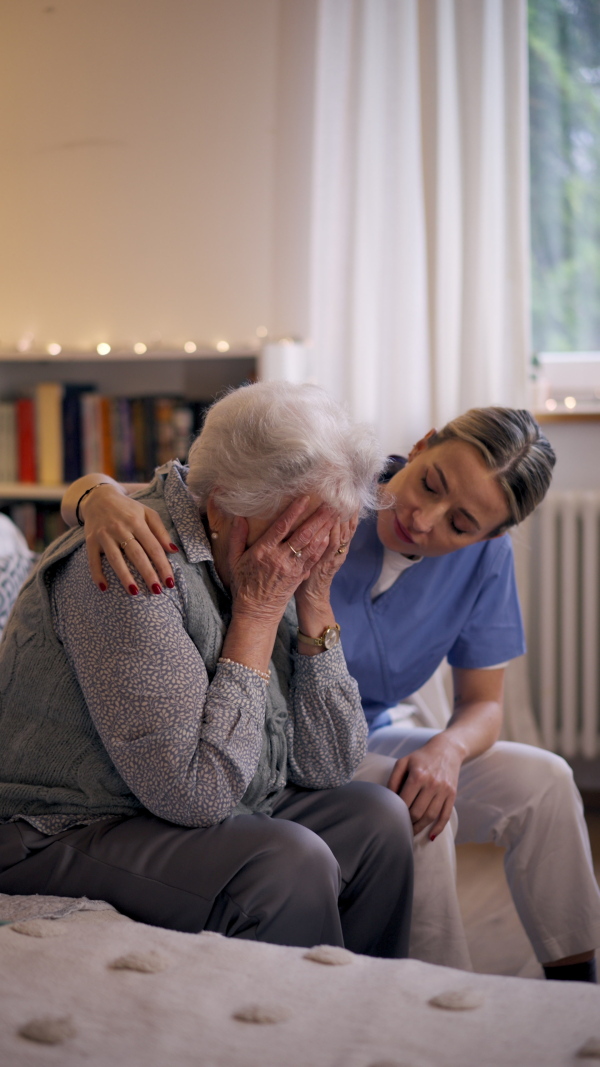 Nurse hugging elderly patient, mental health support and grief counseling to a senior woman.