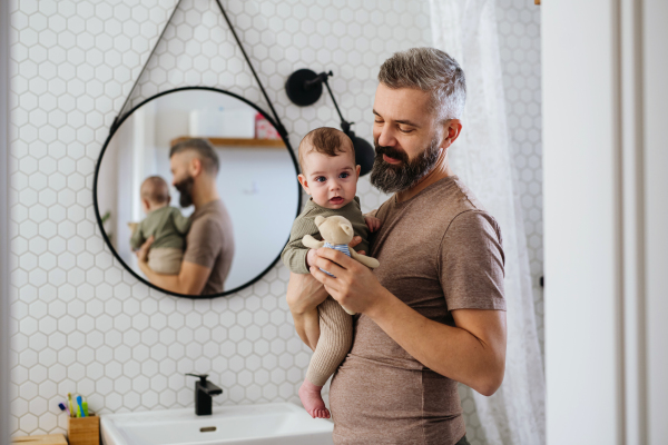 Portrait of father holding baby son in his arms.