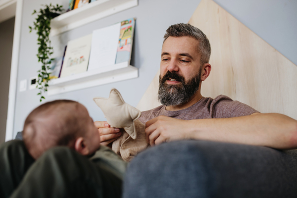 Father holding a baby boy on his lap.