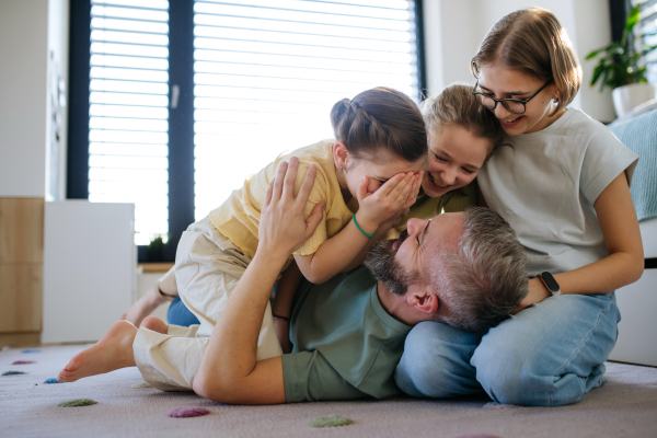 Portrait of father with three daughters at home. Girl dad concept.