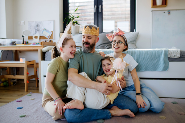 Portrait of father with three daughters at home. Girl dad concept.
