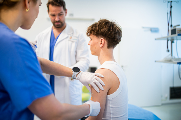 Teenage boy receiving vaccination during routine health checkup at hospital