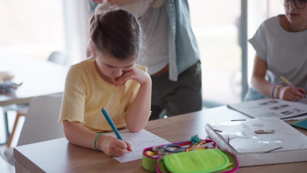 Father helping his daughters with their homework.
