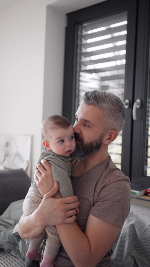A father with his baby son, holding him in arms.