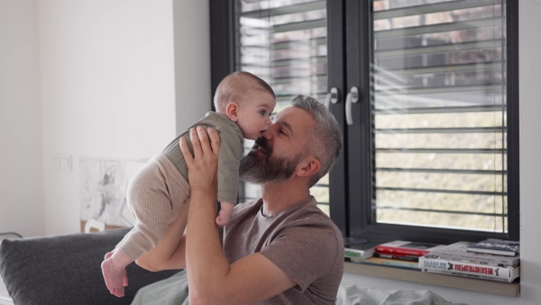 A father with his baby son, holding him in arms.