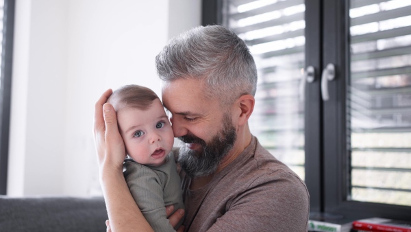 A father with his baby son, holding him in arms.
