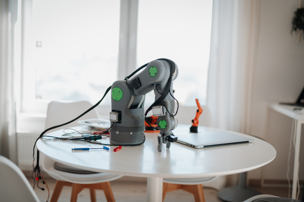 Robotic arm prototype on kitchen table in a home workspace.
