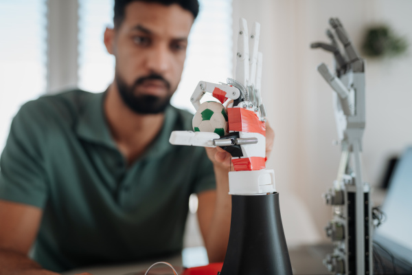 Young engineer building and programming a robotic arm at home. Robotics concept.