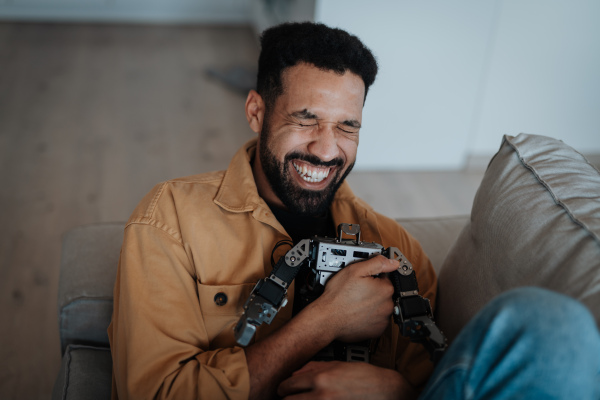Handsome man hugging small robot like a real friend.