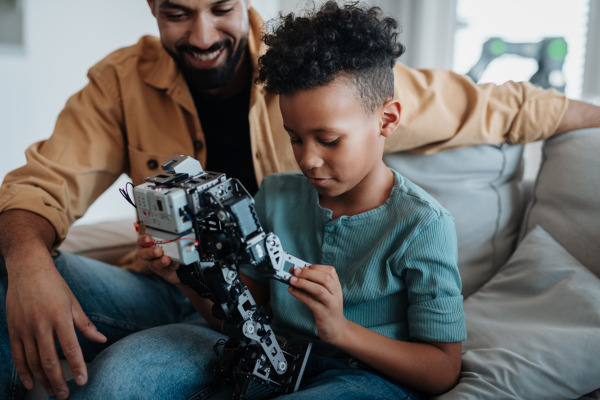 Father teaching son about STEM, robotics, and discussing technology at home.