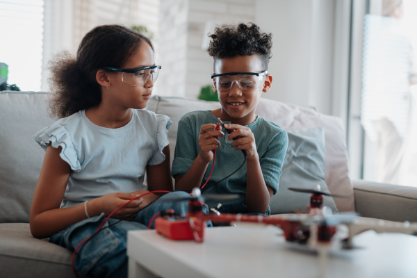 Kids building their first homemade robot at home. Educational robotic kit for children.