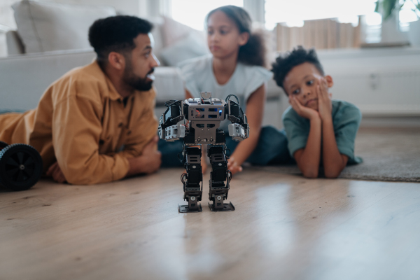 Father teaching kids about STEM, robotics, and discussing technology at home.