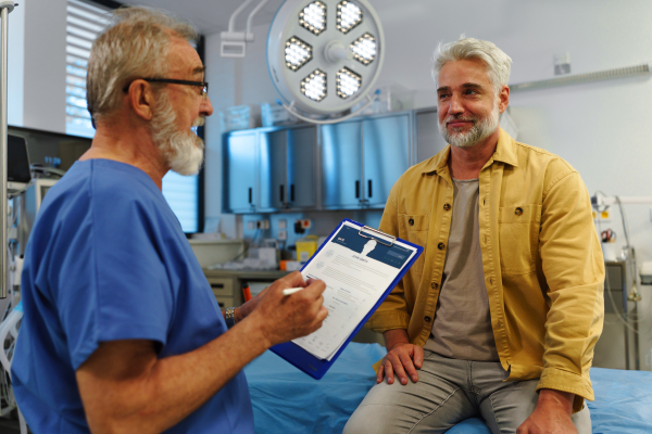 Patient sitting on examination table, describing health problems and symptoms to doctor.