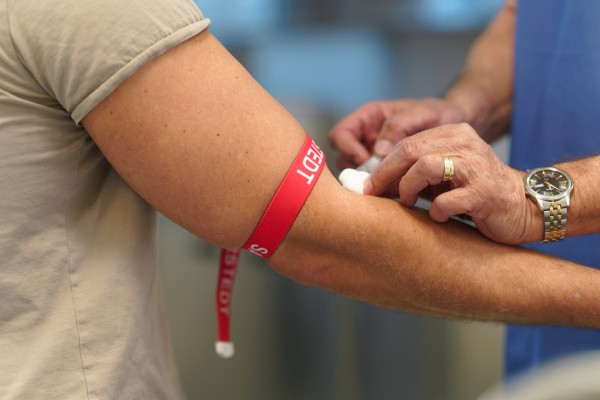 Close up of drawing blood from patient's arm during medical examination.