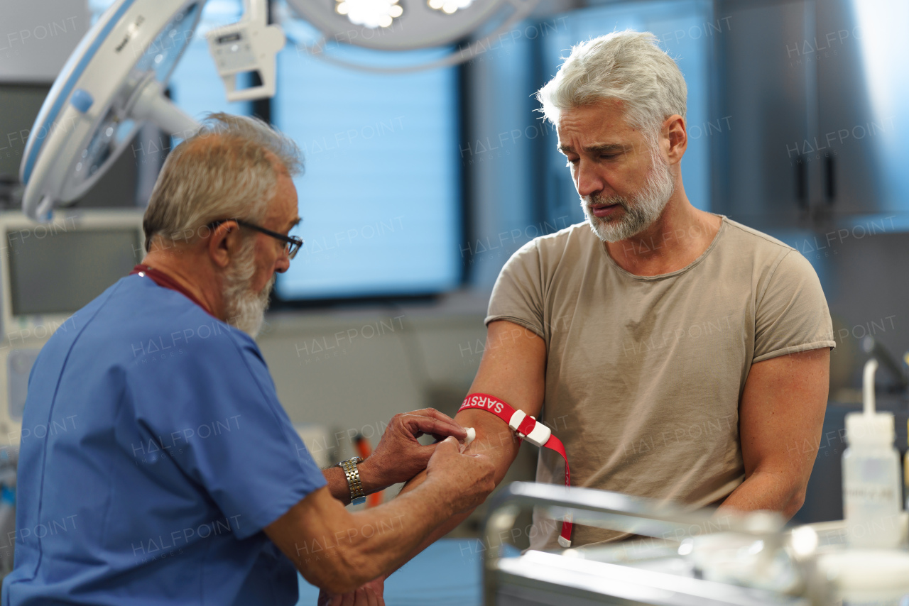 Doctor drawing blood from patient's arm during medical examination.