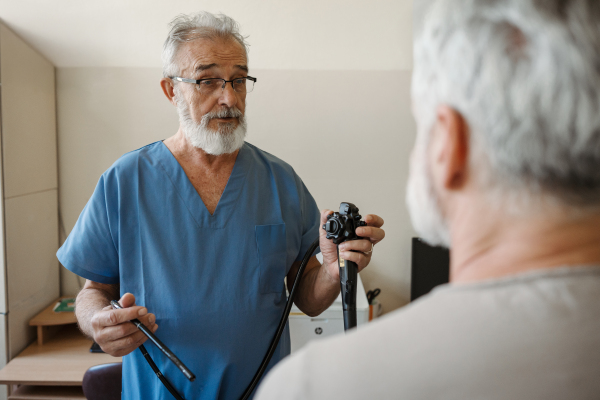 Doctor explaining gastroscopy procedure on patient. Examination of upper digestive tract. Medical procedure.