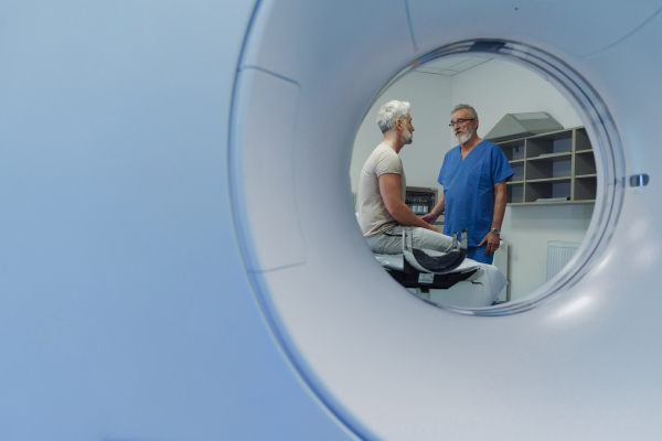 Doctor explaining CT scan results to male patient in hospital setting