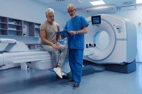 Doctor explaining CT scan results to male patient in hospital setting