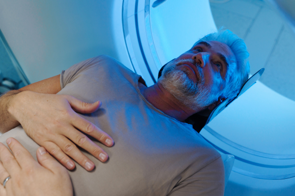 Male patient undergoing CT scan examination in a hospital.