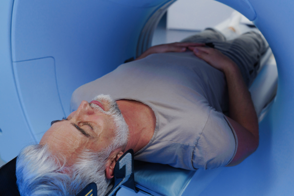 Male patient undergoing CT scan examination in a hospital.