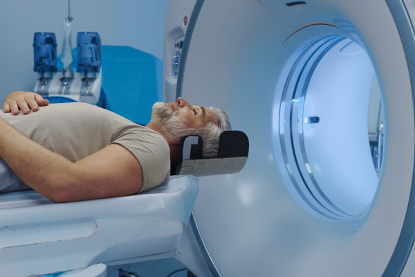 Male patient undergoing CT scan examination in a hospital.