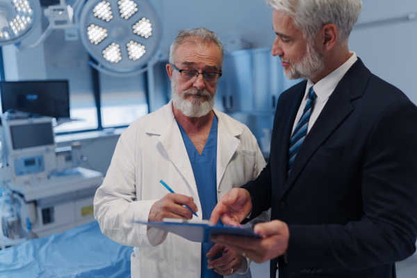 Doctor signing contract with pharmaceutical representative, successful deal.