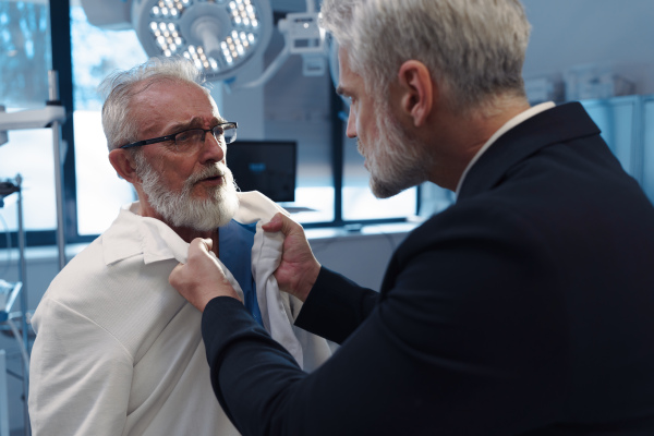 Violence against health workers. Patient is aggressive, have conflict with doctor, holding him by coat.