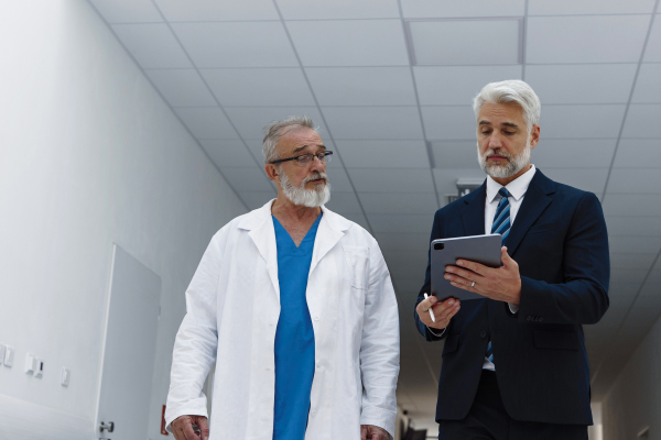 Doctor talking with pharmaceutical representative, hospital setting.