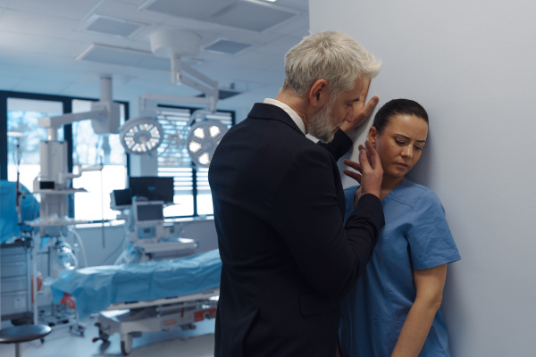 Pharmaceutical representative or hospital manager harassing attractive nurse in healthcare setting.