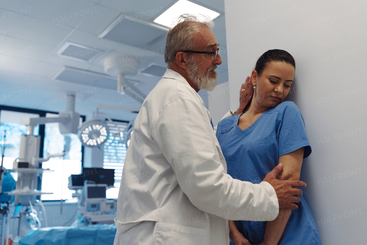Inappropriate behavior between senior doctor and female nurse in hospital hallway. Workplace harassment.