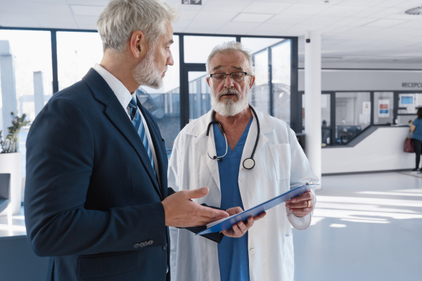 Doctor talking with pharmaceutical representative, hospital setting.