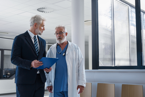 Doctor talking with pharmaceutical representative, hospital setting.
