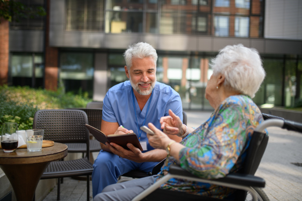 Doctor explaining medication to senior patient and answering her questions about diagnosis.